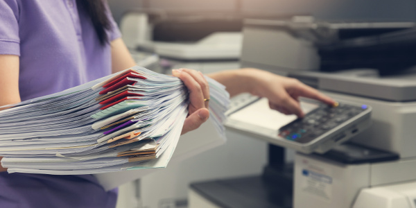 Legal staff member with loads of paper to be scanned